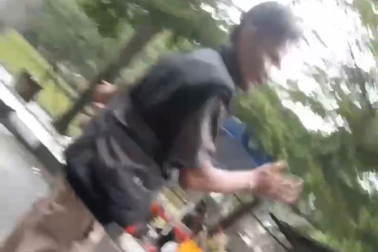 Salah seorang okunum juru parkir di Komplek Pemda Kabupaten Bandung, Jawa Barat, saat melakukan aksinya dengan cara memintai sejumlah uang di Taman Uncal dan Taman Anak Sabilulungan, pada Minggu (18/2/2024)