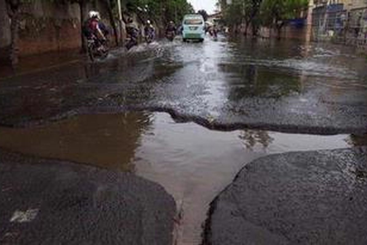 Pengguna kendaraan menghindari jalan rusak dan berlubang di Jalan Lodan Raya, Jakarta Utara, Senin (21/1/2013). Genangan air yang berhari-hari merendam aspal membuat jalan cepat rusak. 