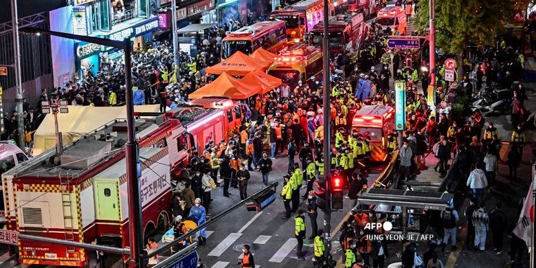 Pengunjung, polisi, dan paramedis berkumpul di lokasi tragedi Halloween Itaewon di Seoul, Korea Selatan, Minggu (30/10/2022) dini hari. Puluhan orang mengalami gagal jantung setelah berhimpitan di gang sempit untuk merayakan Halloween.