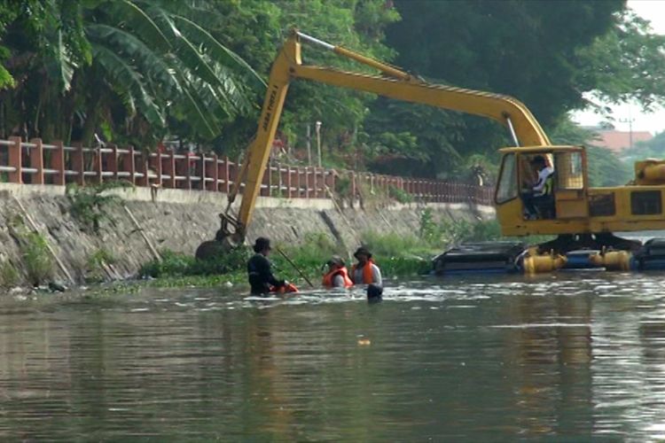 Para petugas menggunakan alat berat melakukan normalisasi saluran di Sungai Kalimas, Surabaya, Jawa Timur