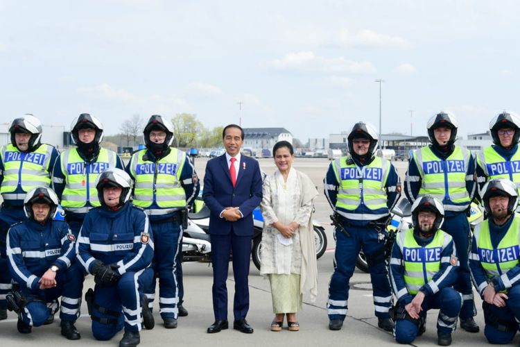 Presiden Joko Widodo dan Ibu Negara Iriana Joko Widodo berfoto bersama polisi Jerman yang kendaraan kepresidenan sesaat sebelum lepas landas dari Bandara Hannover di Jerman menuju Bandara Soekarno Hatta di Tanah Air pada Senin (17/4/2023).