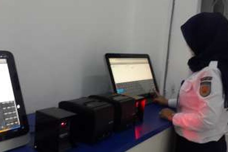 Salah seorang petugas Stasiun Kota Baru Malang saat mengecek mesin Check In Mandiri (CIM), Kamis (28/7/2016)