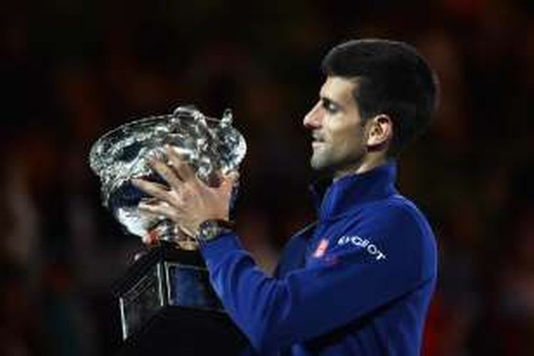 Petenis Serbia, Novak Djokovic, mengangkat trofi juara Australia Terbuka yang didapat setelah mengalahkan Andy Murray (Inggris Raya) di Rod Laver Arena, Melbourne Park, Minggu (31/1/2016).