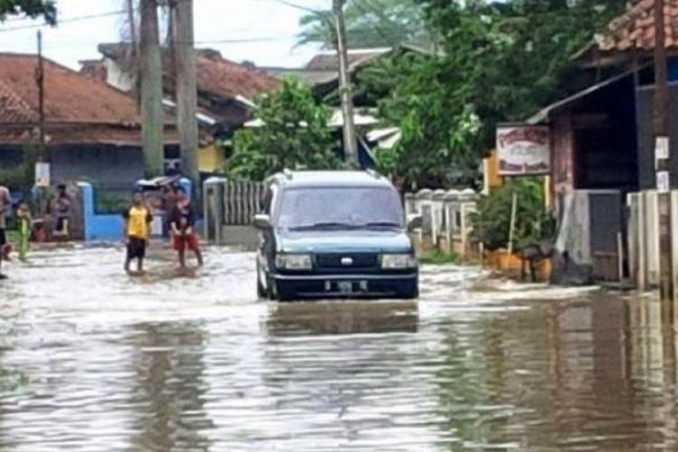 Sebuah mobil mencoba menerobos banjir di kawasan Sapan, Kampung Cikeruh, Desa Tegalluar?, Kecamatan Bojongsoang, Kabupaten Bandung, Rabu (8/3/2017). 
