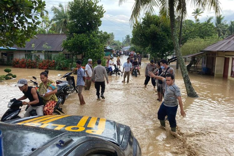 Personel Polres Padang Lawas mengevakuasi warga yang terdampak banjir di Kabupaten Padang Lawas, Sumatera Utara, Sabtu (27/3/2021). Banjir sedikitnya merendam 8 desa di 3 kecamatan, juga mengakibatkan 2 jembatan putus, disebabkan luapan Sungai Barumun.