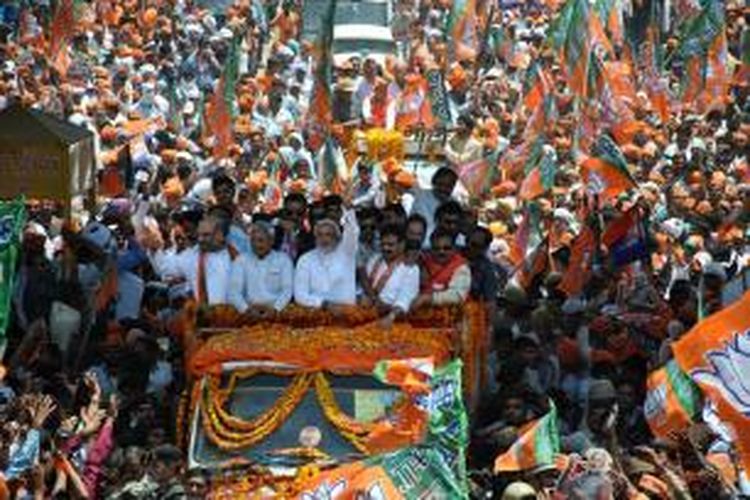 Dalam foto yang diambil pada 24 April 2014 ini, kandidat perdana menteri Bharatiya Janata Party (BJP), Narendra Modi (tengah), melambaikan tangannya kepada ribuan pendukung yang menyambutnya di kota Varanasi. Partai BJP dipastikan memenangkan pemilu India dan sekaligus mengakhiri kepemimpinan Partai Kongres selama 10 tahun terakhir.