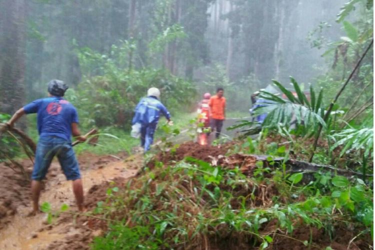 Warga dibantu TNI, Polri, dan BPBD Banjarnegara berupaya menyingkirkan material longsor yang menutup ruas jalan penghubung Kecamatan Madukara dan Pagentan, Jumat (29/9/2017).