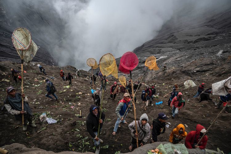 Villagers use nets to catch offerings thrown by members of the Tengger sub-ethnic group in the crater of the active Mount Bromo volcano as part of the Yadnya Kasada festival in Probolinggo, East Java province on June 16, 2022. Juni Kriswanto / AFP