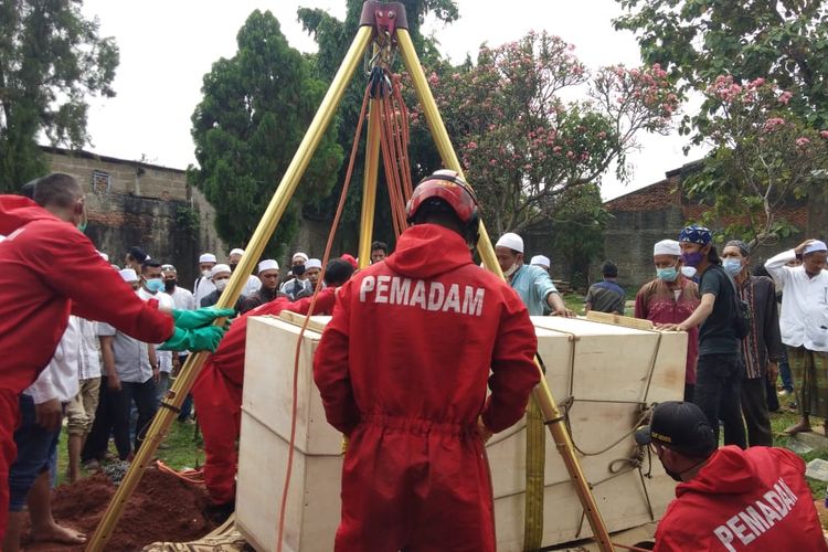 Petugas Suku Dinas (Sudin) Penanggulangan Kebakaran dan Penyelamatan (PKP) Jakarta Timur membantu proses pemakaman warga Klender, Duren Sawit, bernama Abdul Fahmi (25), Selasa (13/7/2021).