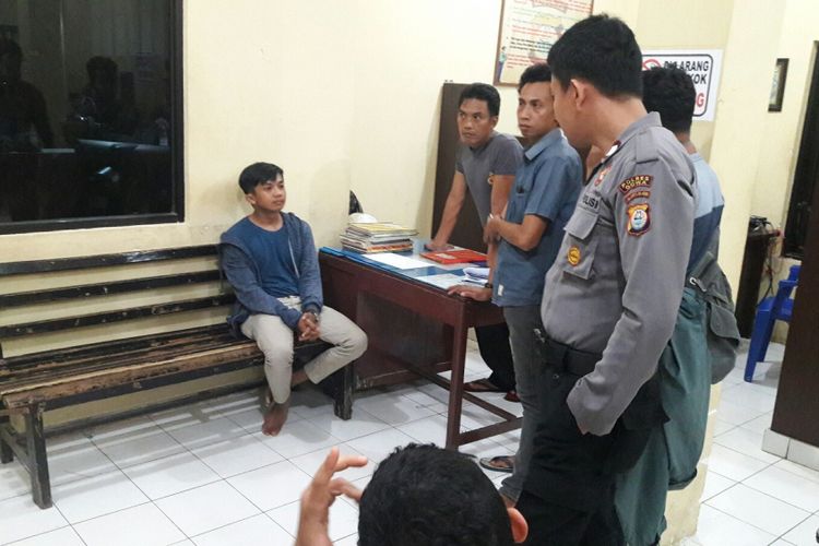 WA (21) tengah diinterogasi aparat Kepolisian Resor (Polres) Gowa, Sulawesi Selatan usai dievakuasi dari kepungan massa setelah mengembalikan harta milik korban yang dijambretnya. Selasa, (24/10/2017).