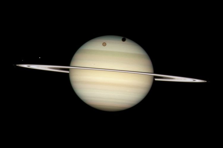Ilustrasi Titan bulan Saturnus saat mengorbit di planet bercincin. Bulan terbesar di tata surya, setelah Ganymede bulan Jupiter.
