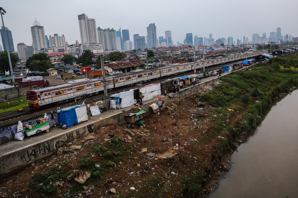 Kereta listrik (KRL) melintas di samping deretan bangunan liar di sepanjang tepi Sungai Ciliwung, Jalan Tenaga Listrik, Tanah Abang, Jakarta Pusat, Sabtu (30/9/2017). Gubuk liar kembali berdiri di sepanjang Sungai Ciliwung akibat kurangnya pengawasan dari Pemprov DKI Jakarta.