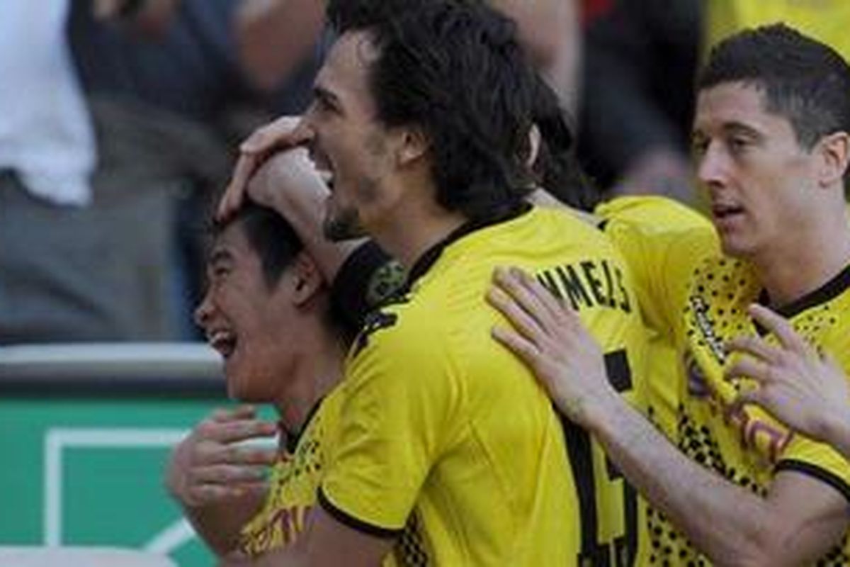 Pemain Borussia Dortmund asal Jepang, Shinji Kagawa (depan) disambut Robert Leandowski dan Mats Hummels setelah membobol gawang FC Koeln. Dia mencetak dua gol dan timnya menang 6-1 atas Koeln pada lenjutan Bundesliga 1, Minggu (25/3/2012).
