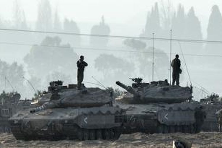 Para prajurit Israel berdiri di atas kubah tank Merkava yang dikerahkan ke dekat perbatasan dengan Jalur Gaza, Selasa (8/7/2014). Ketegangan antara Israel-Gaza terus meningkat sejak peristiwa dibunuhnya seorang remaja Palestina oleh kelompok ekstremis Yahudi sebagai balasan atas pembunuhan tiga remaja Israel di Tepi Barat.