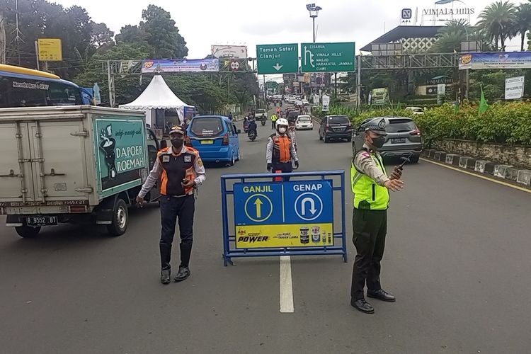 Petugas Satlantas Polres Bogor menjaring kendaraan yang melanggar aturan ganjil genap di Puncak Bogor, Jawa Barat, Sabtu (24/12/2022).