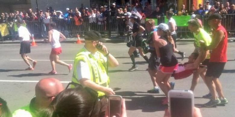 Empat pelari di Maraton Boston, Senin (21/4/2014), membantu satu pelari lain yang sudah nyaris roboh di kilometer terakhir maraton ini.