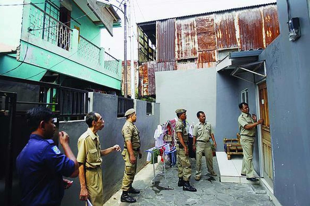 Petugas gabungan mengetuk pintu rumah indekos dalam Operasi Yustisi Kependudukan (OYK) di RT 001 RW 05, Kelurahan Kebon Baru, Kecamatan Tebet, Jakarta Selatan, Kamis (22/9). Pemprov DKI melaksanakan OYK secara serentak di lima wilayah. Pendatang yang tidak memiliki KTP setempat didenda Rp 20.000.
