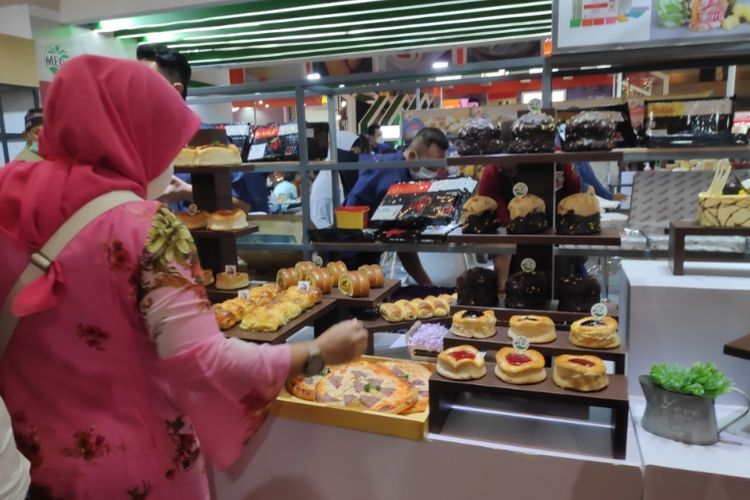 Pengunjung Sial Interfood 2022 melihat produk roti dan kue yang dipamerkan. 