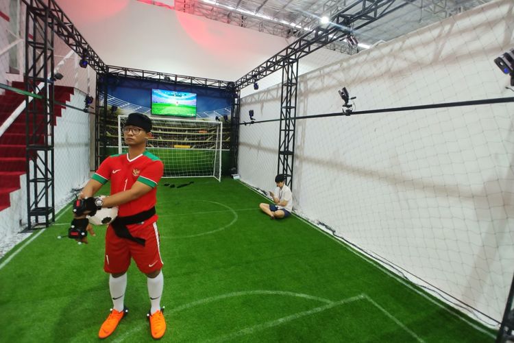 Game sepakbola adu penalti di mana kiper mengenakan headset VR mencoba menangkap bola yang ditendang pengunjung.