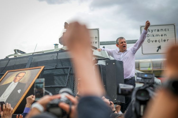 Ozgur Ozel, mantan ketua Partai Rakyat Republik (CHP) yang merupakan partai oposisi utama, sedang memberi isyarat di atas kendaraan penyemprot air saat ia dan para pendukungnya berbaris menuju Majelis Nasional Agung Turki (TBMM) setelah penggerebekan polisi di markas partai di Ankara.