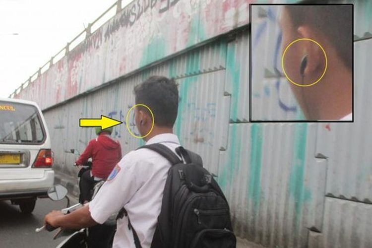 Pakai headset saat berkendara bisa kena tilang.