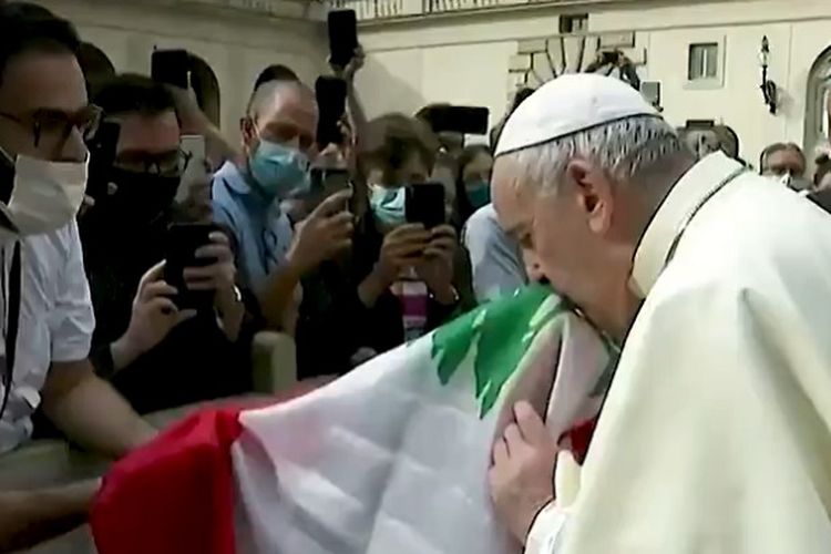 Sri Paus Fransiskus tampak mencium bendera Lebanon yang disodorkan seorang pastor dalam audiensi umum.