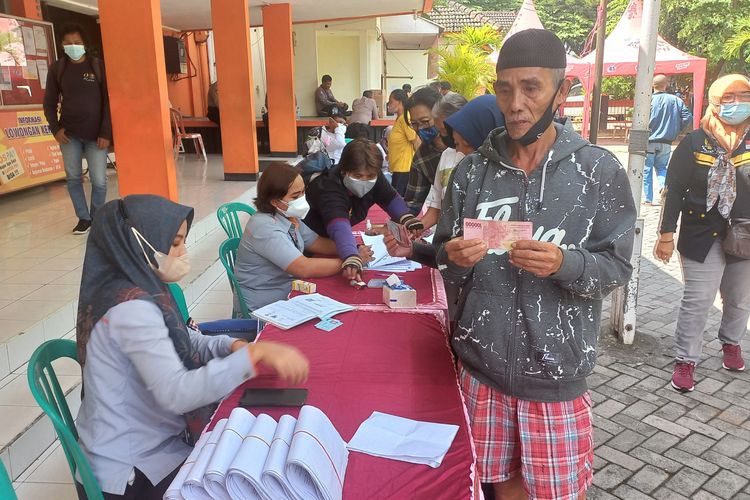 Seorang warga usai menerima bantuan BNPT di Kantor Pos Cabang Kota Kediri, Jawa Timur, Rabu (23/2/2022).