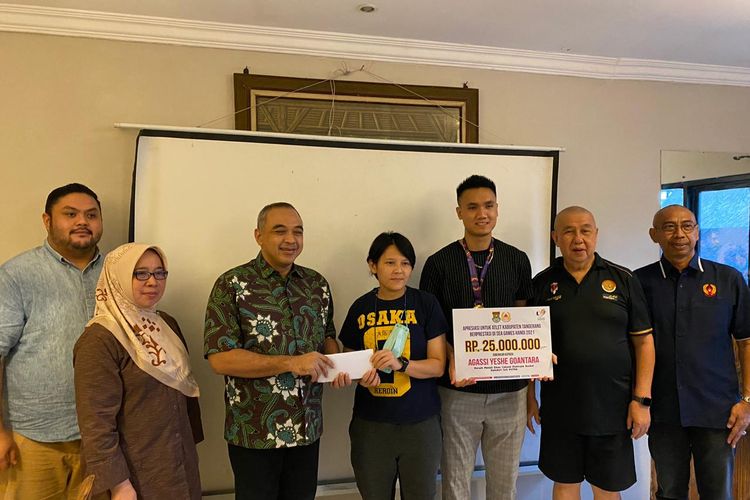 Pelatih timnas basket 3x3 putri Indonesia sekaligus asisten pelatih timnas basket 5x5 putri Indonesia, July Wong (tengah), menerima bonus dari Ketua Pengprov Perbasi Banten Zaki Iskandar usai mengantarkan anak didiknya meraih medali perunggu dan perak SEA Games 2021 Vietnam. 