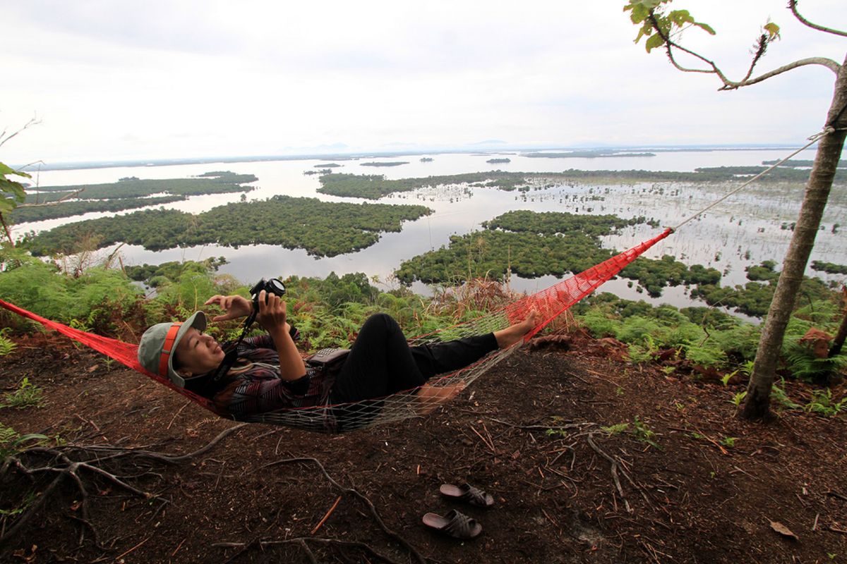 Pengunjung saat menikmati panorama Taman Nasional Danau Sentarum dari puncak Bukit Tekenang, Kalimantan Barat.