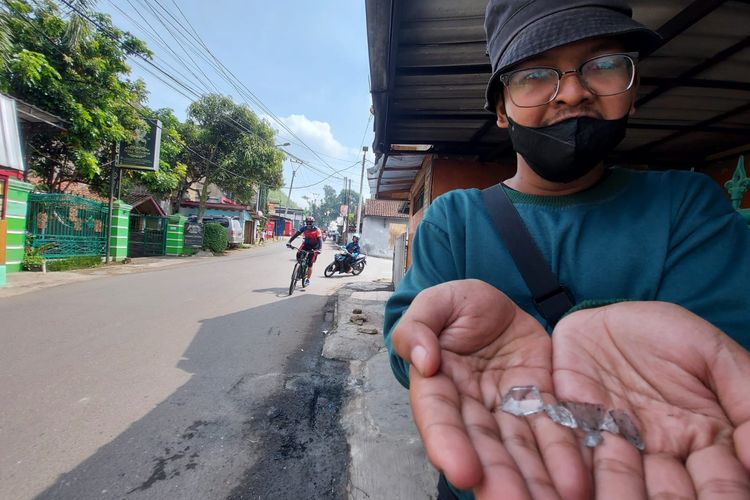 Warga menunjukkan serpihan botol sisa molotov yang digunakan kelompok motor untuk membakar kendaraan roda dua di Cimahi.