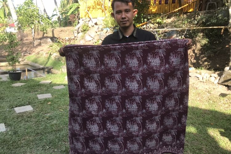 Pemilik usaha batik khas Minang bermerek Salingka Tabek, Yusrizal (29) saat ditemui di rumahnya di Sawah Parik, Desa Bawah Duku, Kecamatan Kotobaru, Solok, Sumatera Barat pada Rabu (18/5/2022). Ia memegang kain batik bermotifkan rumah gadang.