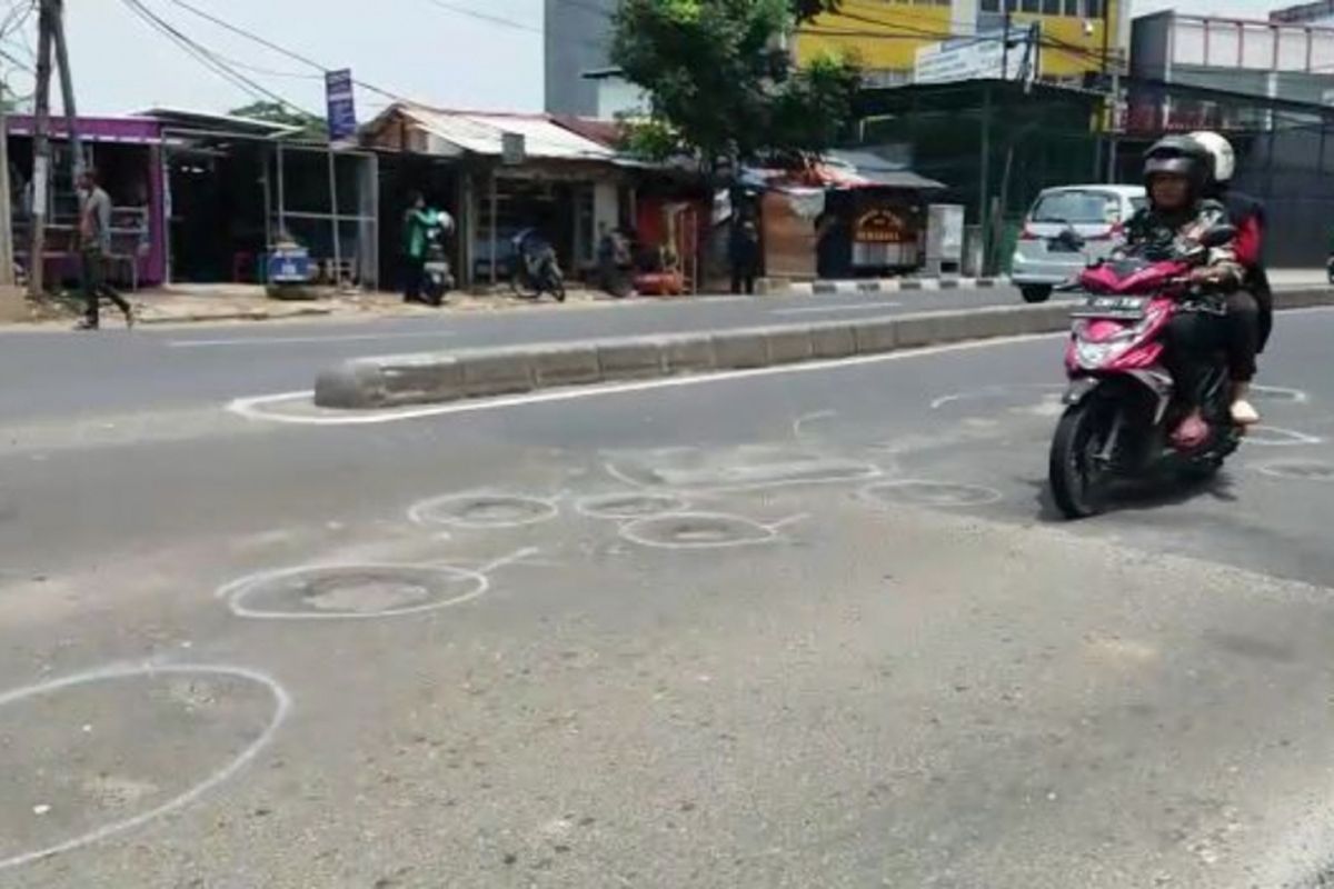 Nampak Jalan Ir. Juanda, Kota Bekasi berlubang dan diberi tanda cat putih untuk ditambal nantinya, Senin (4/2/2019).