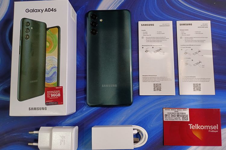 Kotak kemasan Samsung Galaxy A04s mencakup aksesori SIM Card eject tool, buku panduan, kartu garansi, adapter charger 15 watt, serta kabel data USB-A ke US-C.