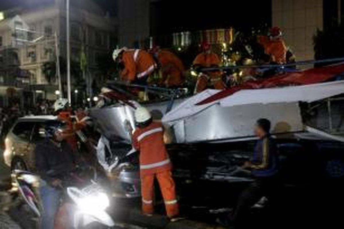 Papan reklame roboh akibat hujan deras yang disertai angin kencang di depan BCA Wisma Asia, Jalan S Parman, Jakarta, Selasa (22/4/2014). Papan reklame menimpa satu mobil, dua truk dan tiga sepeda motor. Kejadian tersebut mengakibatkan sejumlah orang luka-luka.