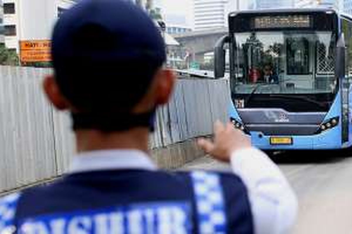 Petugas berjaga di jalur bus transjakarta di Jalan Jenderal Sudirman, Jakarta Pusat, Senin (13/6/2016). Pemprov DKI Jakarta telah mencanangkan akan menilang dan mendenda bagi kendaraan umum yang menerobos jalur bus transjakarta mulai hari ini. Hanya kendaraan tertentu yang boleh melintas, yakni ambulans, mobil pemadam kebakaran, dan mobil dinas berpelat RI.