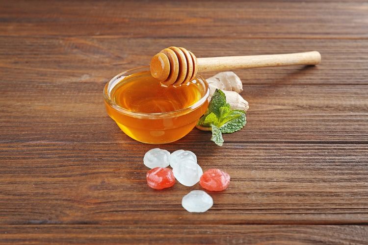 Ilustrasi mengonsumsi madu untuk redakan batuk.