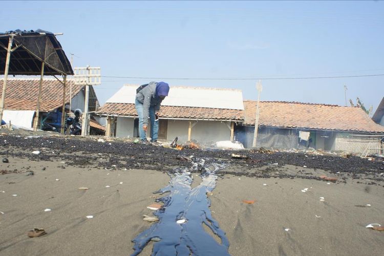 Api dinyalakan di tumpahan minyak di pantai Desa Cemarajaya, Kecamatan Cibuaya, Kabupaten Karawang, Senin (22/7/2019).