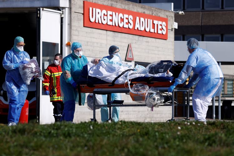 Seorang pasien yang terinfeksi virus corona dibawa dengan brankar oleh petugas medis Perancis sebelum diterbangkan menggunakan helikopter dari rumah sakit Strasbourg ke Pforzheim, Jerman, pada 24 Maret 2020.