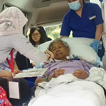 Petugas PPLN Singapura memberikan penjelasan tata cara mencoblos kepada Bigman Sirait yang mencoblos di dalam ambulans di kompleks KBRI di Singapura, Minggu (14/4/2019). (KOMPAS.com/ERICSSEN)