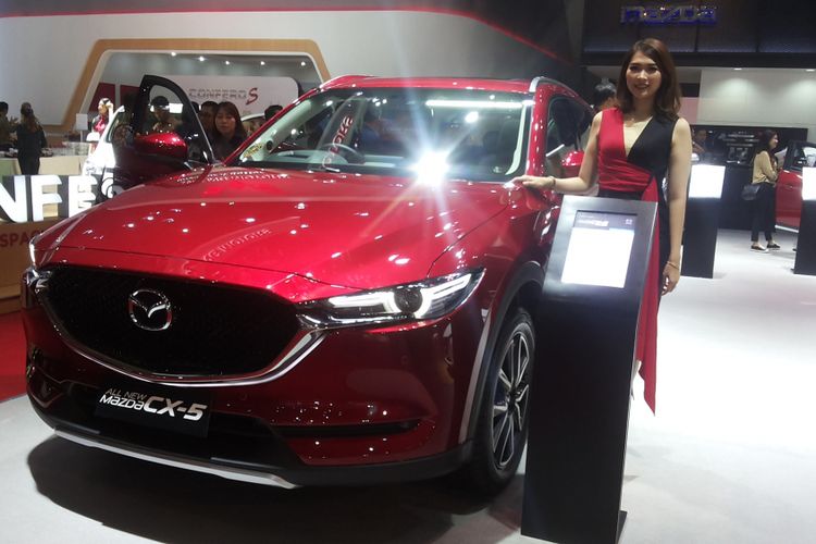 Seorang sales promotion gilr (SPG) memperkenalkan salah satu produk andalan Mazda di stan Eurokars Motor Indonesia saat hari pertama ajang Indonesia International Motor Show (IIMS) 2018 di JIExpo Kemayoran, Jakarta, Kamis (19/4/2018).