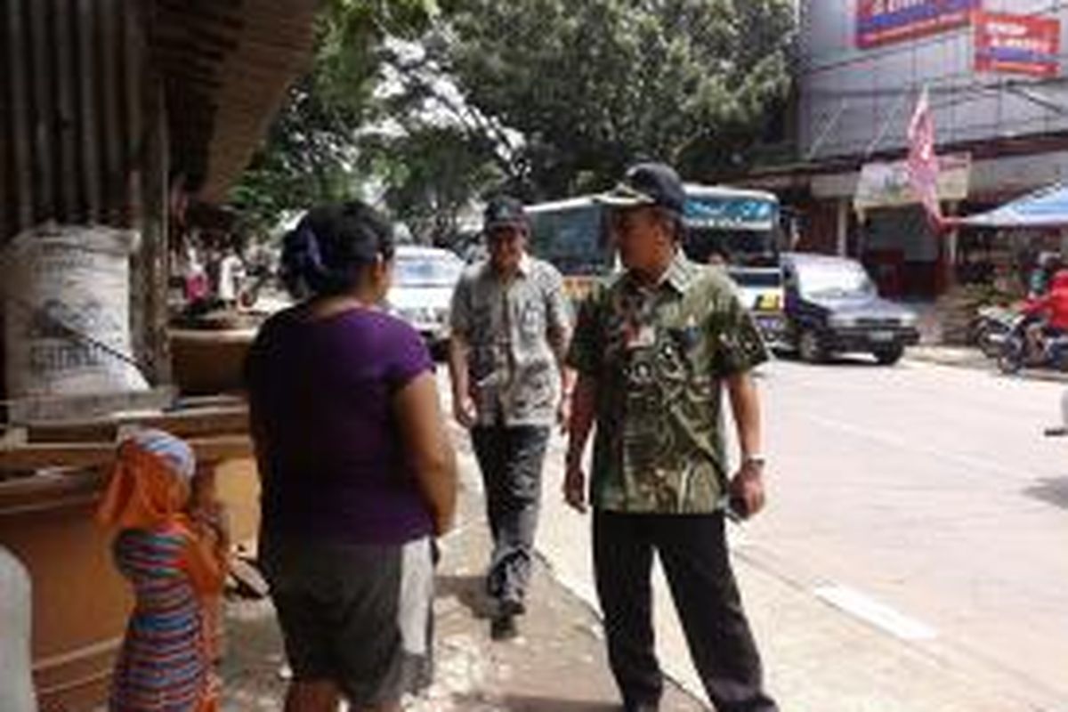 Camat Jagakarsa Fidiyah Rokhim (kanan) menemui salah satu pedagang saat pembagian SP 1 di Jalan Lenteng Agung, Kamis, (15/1/2015). 