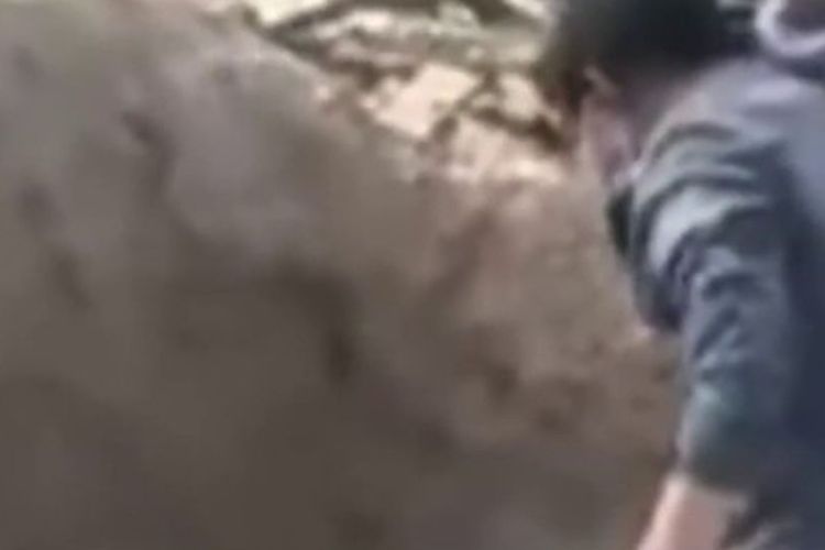 Tangkapan dari video memperlihatkan momen ketika Kepolisian Jingbian, China, mengeluarkan ibu berusia 79 tahun yang lumpuh dari sebuah makam kosong. Ibu itu dilaporkan dikubur hidup-hidup oleh anaknya.