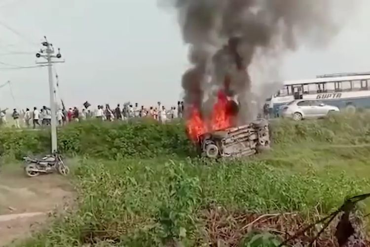 Mobil yang terbakar dalam insiden tabrakan di tengah unjuk rasa petani dan menyeret anak menteri dalam negeri India. [SS/YOUTUB/HINDUSTAN TIMES]