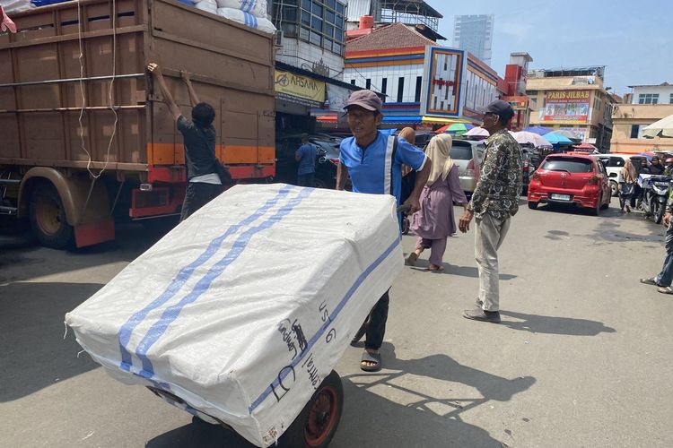 Subarnas (65) mendorong lori dengan muatan sekitar 50 kilogram pakaian menuju toko yang mengordernya di Pasar Tengah, Kota Bandar Lampung, Rabu (15/3/2023) pagi.