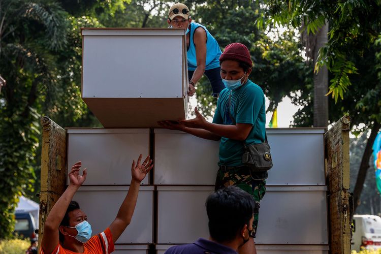 Pekerja mengangkat peti untuk dipindahkan ke mobil ambulans di TPU Petamburan, Jakarta Pusat, Minggu (4/7/2021). Dinas Pertamanan dan Hutan Kota DKI Jakarta menyiapkan peti Covid-19 untuk Rumah sakit dan pasien Covid-19 yang diisolasi di rumah di seluruh Jakarta.