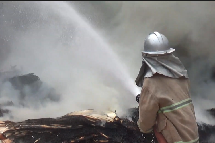 Petugas pemadam kebakaran memadamkan api yang membakar pabrik kayu di Lumajang, Minggu (9/6/2024)