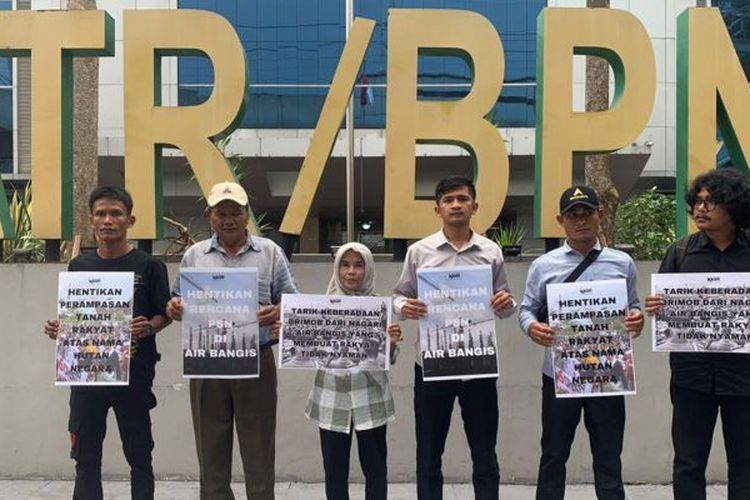 Sejumlah warga Air Bangis dan aktivis lingkungan memegang poster di depan gedung Kementerian ATR/BPN untuk memprotes perampasan lahan rakyat.
