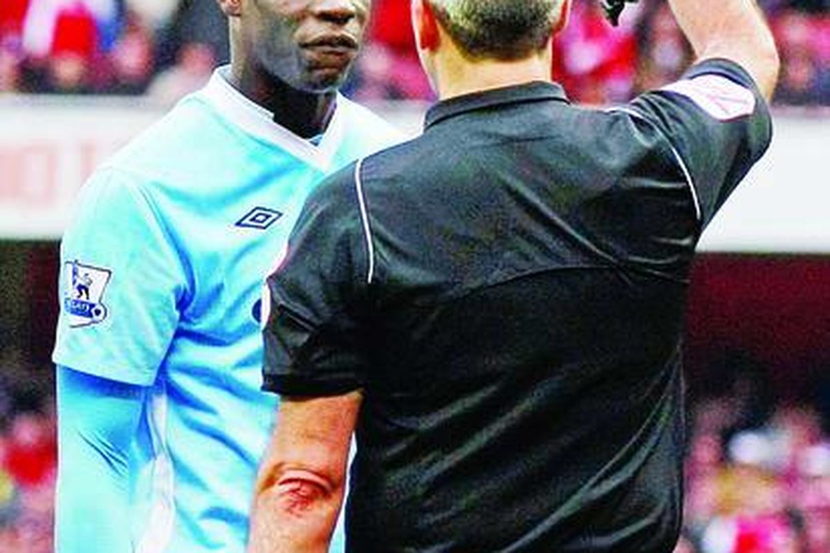 Pemain Manchester City, Mario Balotelli (kiri), mendapat kartu merah dari wasit Martin Atkinson kala melawan Arsenal di Stadion Emirates, London, Minggu (8/4).