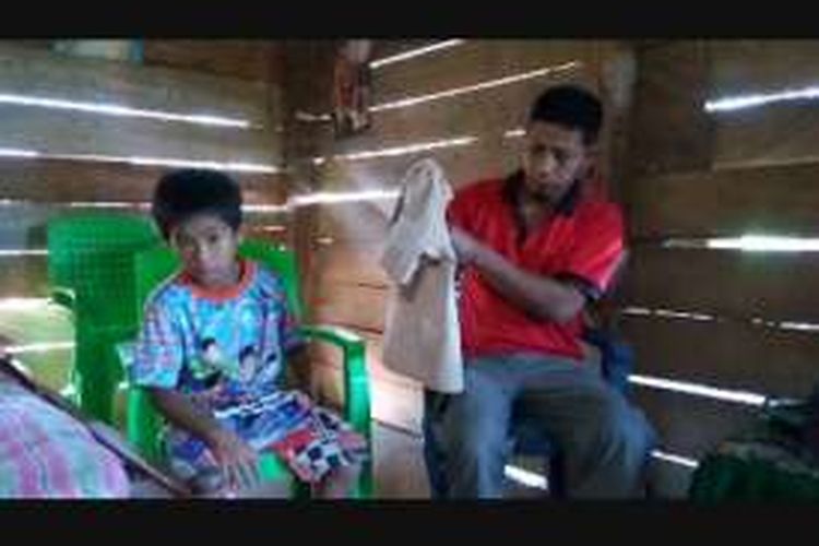 Adil (11), siswa kelas V SD Negeri 147 Pangaparang, Kecamatan Lembang, Kabupaten Pinrang, Sulawesi Selatan, mendapatkan bantuan baju seragam pramuka dari sekolahnya, Minggu (18/9/2016).