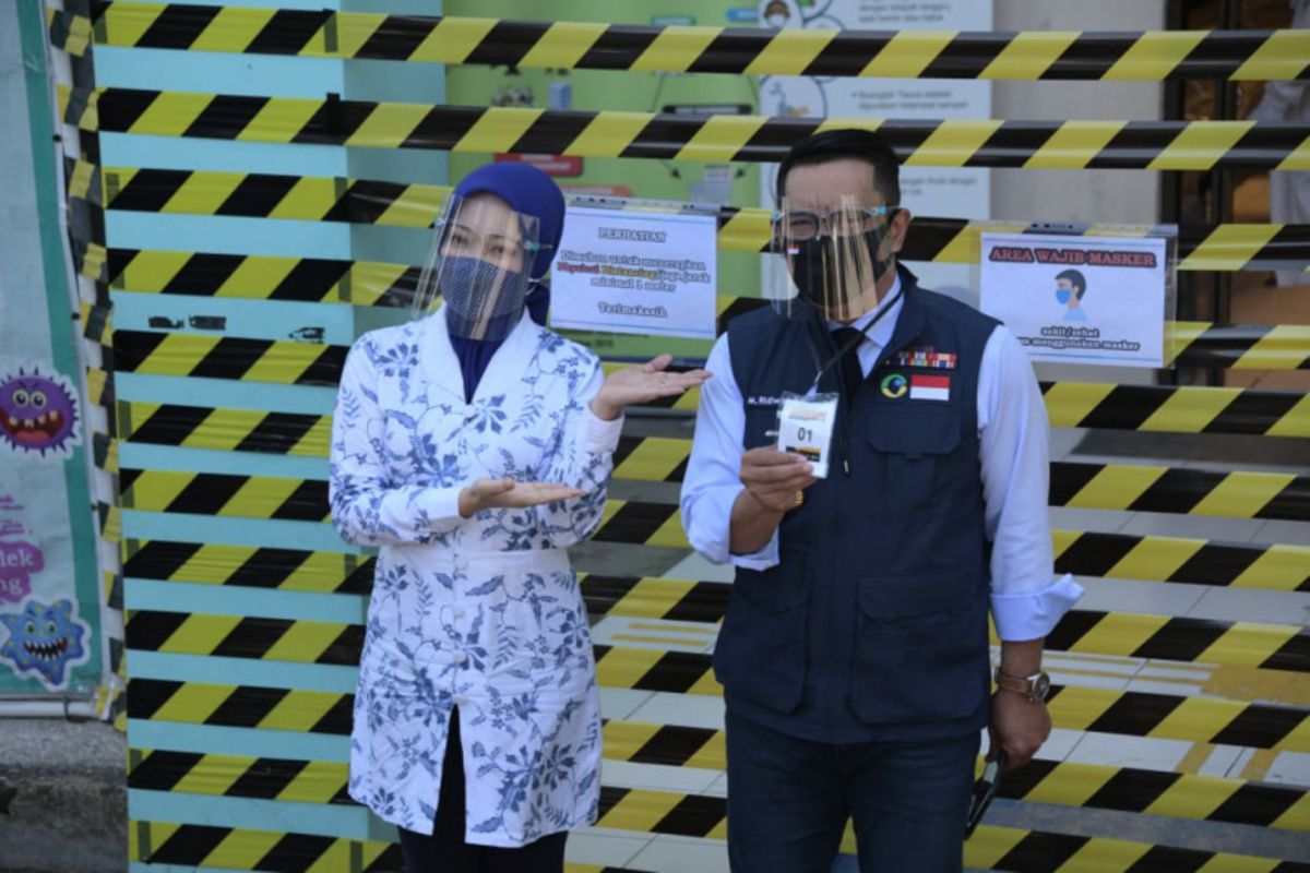 Gubernur Jawa Barat Ridwan Kamil diantar istrinya Atalia Praratya sebelum menjalani tahap pertama uji klinis vaksin Covid-19 di Puskesmas Garuda, Kota Bandung, Selasa (25/8/2020).